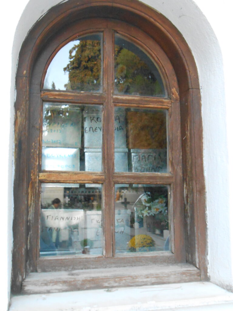 Arched window. The building is packed with tin boxes, each bearing a name.